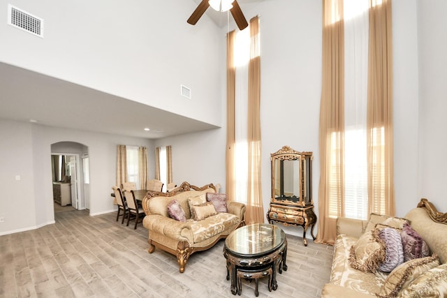 12306 Belhaven Terrace Dr, Houston, TX 77044 - living room with arched walkways, ceiling fan, plenty of natural light, a towering ceiling, and wood finished floors
