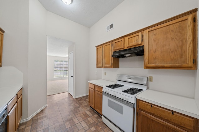 11423 Sunny Creek Dr, Houston, TX 77066 - kitchen with under cabinet range hood, white gas range oven, light countertops, brown cabinetry, and brick patterned flooring