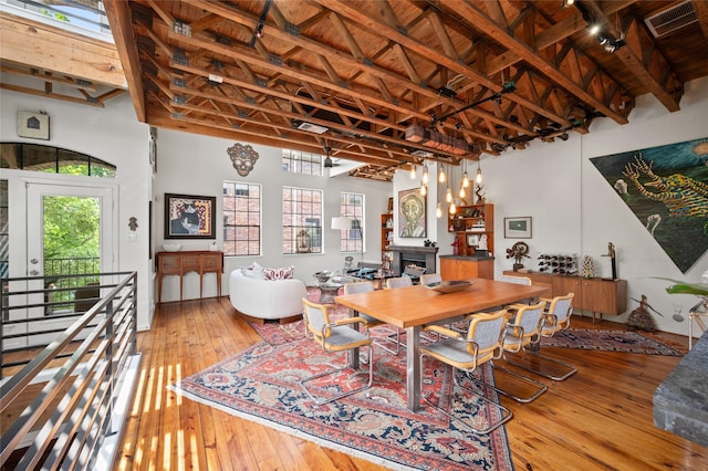 2614 Yoakum Blvd, Houston, TX 77006 - dining room with light wood finished floors, a fireplace, high vaulted ceiling, and a wooden ceiling with exposed beams