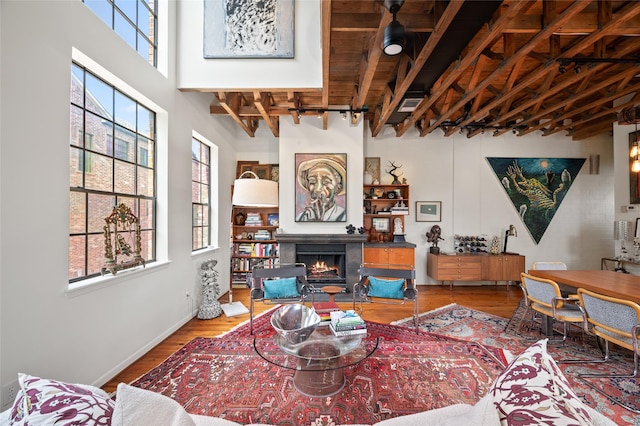 2614 Yoakum Blvd, Houston, TX 77006 - living room with healthy amount of natural light, a lit fireplace, wood finished floors, and beamed ceiling