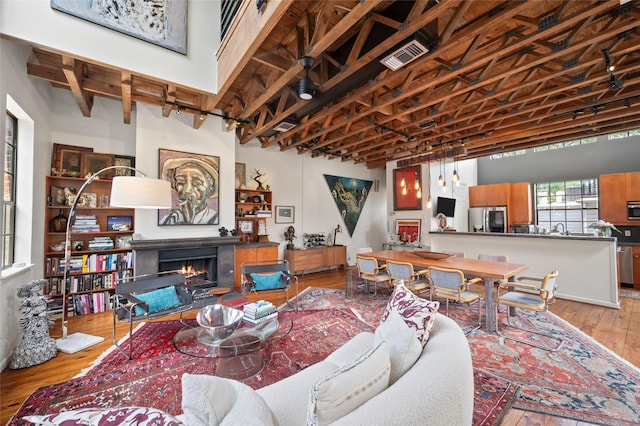 2614 Yoakum Blvd, Houston, TX 77006 - living room featuring hardwood / wood-style floors and a warm lit fireplace