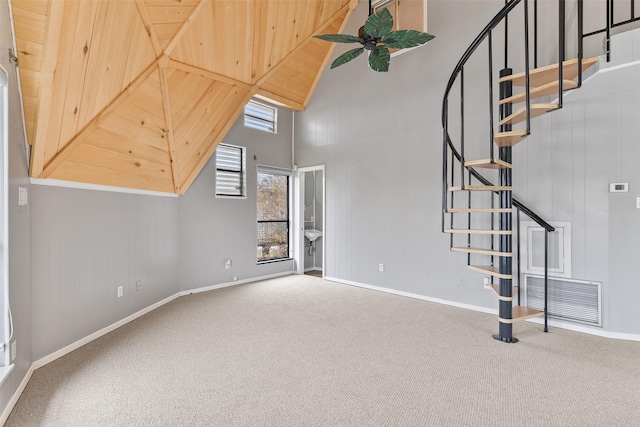 12901 E Barcelona, Galveston, TX 77554 - unfurnished living room featuring carpet, a towering ceiling, and stairs