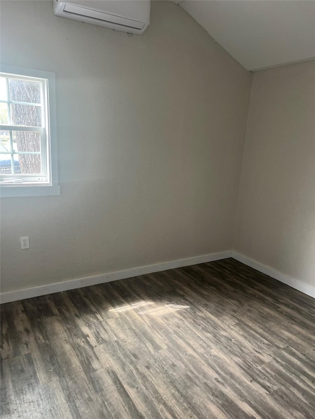 174 Jaycrest, Livingston, TX 77351 - unfurnished room featuring a wall mounted AC, dark wood-style flooring, and vaulted ceiling