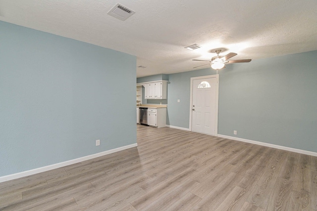 3735 Woodpeckers Grv, Cleveland, TX 77328 - unfurnished living room featuring a ceiling fan, light wood-style flooring, and a textured ceiling