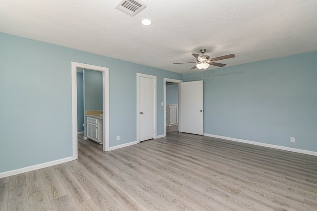 3735 Woodpeckers Grv, Cleveland, TX 77328 - unfurnished bedroom with light wood-style flooring, connected bathroom, ceiling fan, and a textured ceiling
