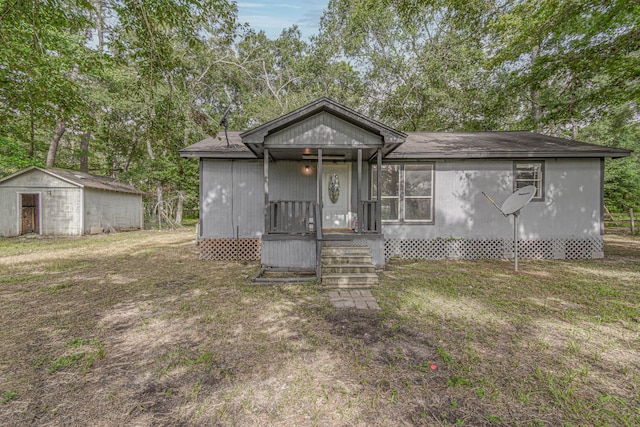 3735 Woodpeckers Grv, Cleveland, TX 77328 - view of front of house featuring an outbuilding, a front lawn, and view of wooded area