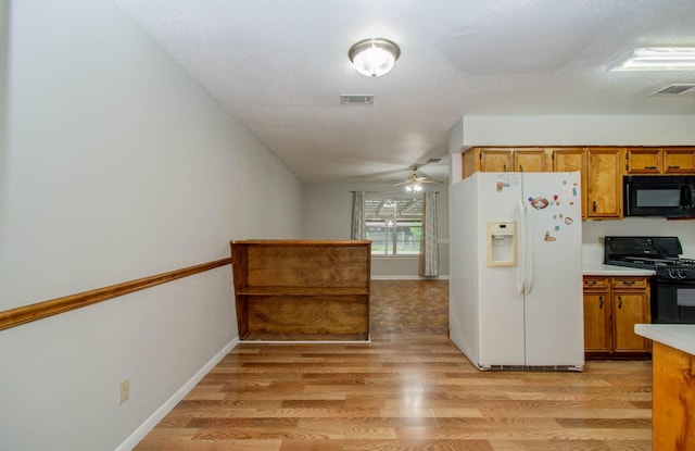 10131 Tangiers Rd, Houston, TX 77041 - kitchen with black appliances, brown cabinets, light wood-style flooring, light countertops, and ceiling fan