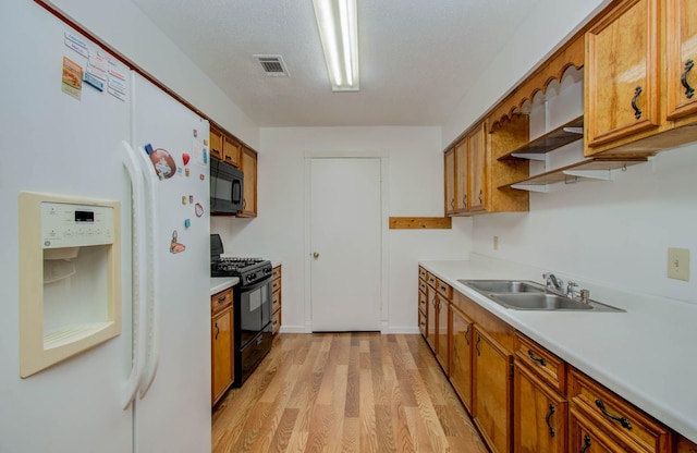 10131 Tangiers Rd, Houston, TX 77041 - kitchen featuring black appliances, brown cabinets, light wood-style floors, and light countertops