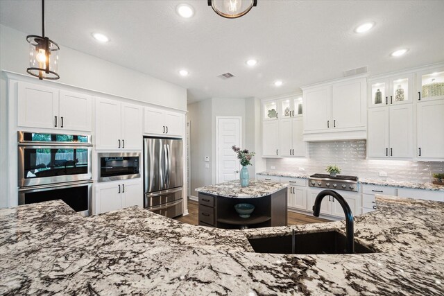 5946 Wedgewood Heights Way, Houston, TX 77059 - kitchen featuring appliances with stainless steel finishes, tasteful backsplash, light stone counters, recessed lighting, and white cabinets