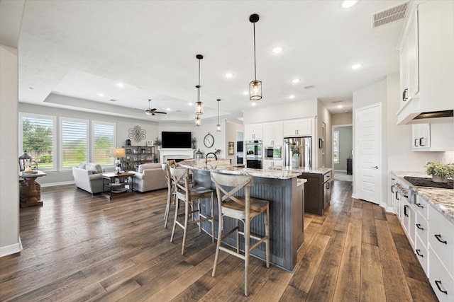 5946 Wedgewood Heights Way, Houston, TX 77059 - kitchen with a center island with sink, open floor plan, stainless steel appliances, ceiling fan, and dark wood-style floors