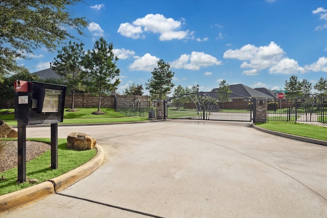 5946 Wedgewood Heights Way, Houston, TX 77059 - view of concrete street featuring curbs, a gate, traffic signs, and a gated entry