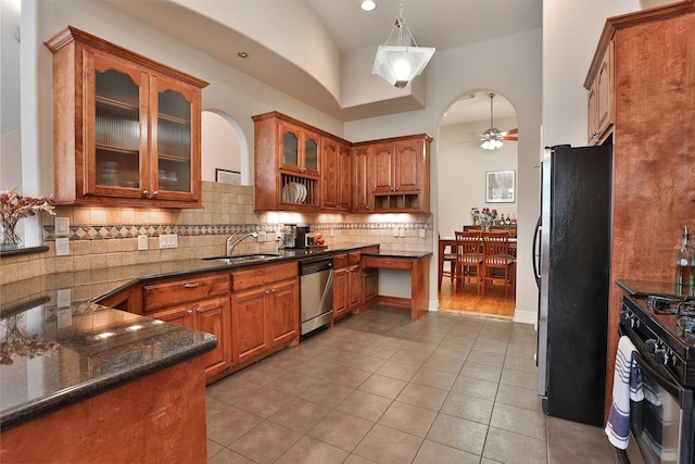 826 E 29th St, Houston, TX 77009 - kitchen with stainless steel appliances, a ceiling fan, brown cabinetry, decorative backsplash, and lofted ceiling