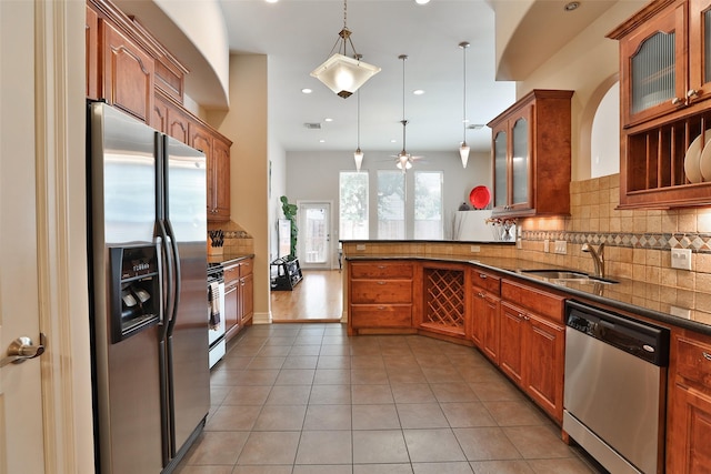 826 E 29th St, Houston, TX 77009 - kitchen with stainless steel appliances, a peninsula, tasteful backsplash, light tile patterned flooring, and decorative light fixtures