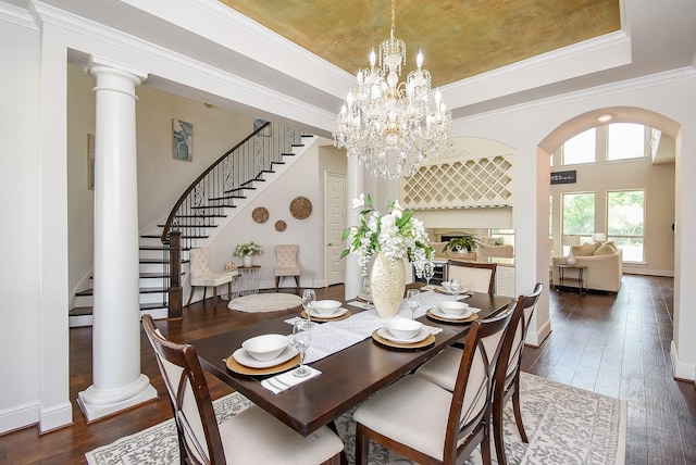 5450 Pudman River Ln, Sugar Land, TX 77479 - dining area featuring a tray ceiling, arched walkways, stairs, wood-type flooring, and ornamental molding