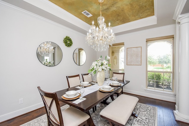 5450 Pudman River Ln, Sugar Land, TX 77479 - dining room featuring a chandelier, a raised ceiling, dark wood-style floors, crown molding, and decorative columns