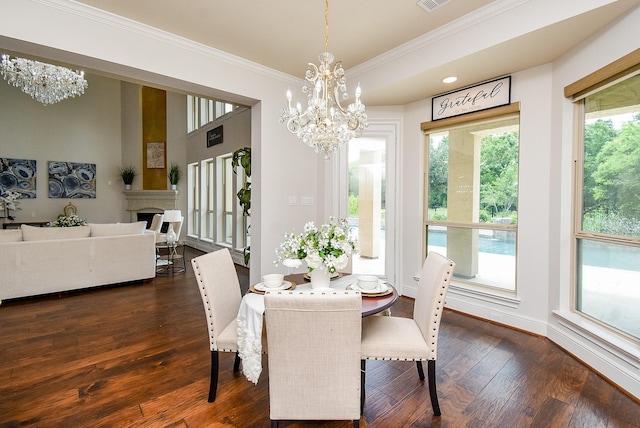 5450 Pudman River Ln, Sugar Land, TX 77479 - dining room featuring a chandelier, crown molding, dark wood-style flooring, and a fireplace