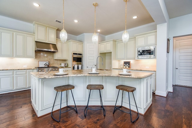 5450 Pudman River Ln, Sugar Land, TX 77479 - kitchen featuring appliances with stainless steel finishes, ventilation hood, cream cabinetry, tasteful backsplash, and light stone counters