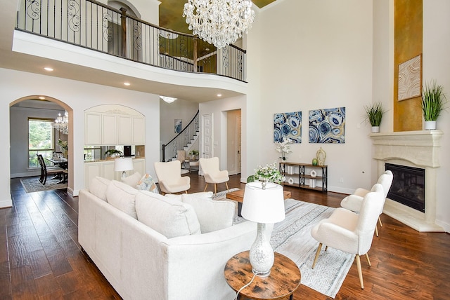 5450 Pudman River Ln, Sugar Land, TX 77479 - living area featuring a towering ceiling, stairs, arched walkways, dark wood finished floors, and a chandelier