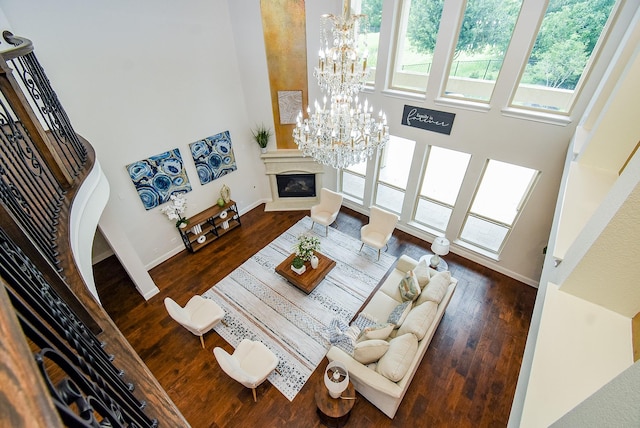 5450 Pudman River Ln, Sugar Land, TX 77479 - living area featuring a glass covered fireplace, a chandelier, and wood finished floors