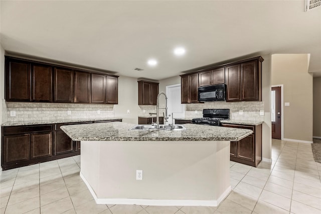 2926 Indwarra Ct, Katy, TX 77494 - kitchen with black appliances, backsplash, light stone counters, a kitchen island with sink, and dark brown cabinetry