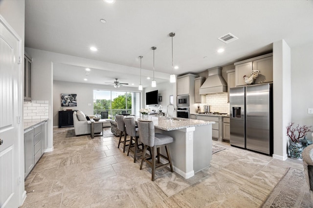 2705 Veranda Vly, League City, TX 77573 - kitchen with stainless steel appliances, premium range hood, gray cabinets, tasteful backsplash, and open floor plan
