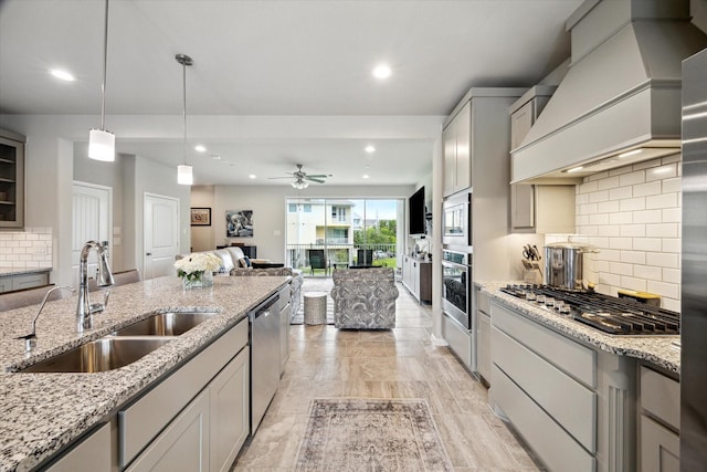 2705 Veranda Vly, League City, TX 77573 - kitchen featuring appliances with stainless steel finishes, custom exhaust hood, ceiling fan, decorative backsplash, and light stone countertops