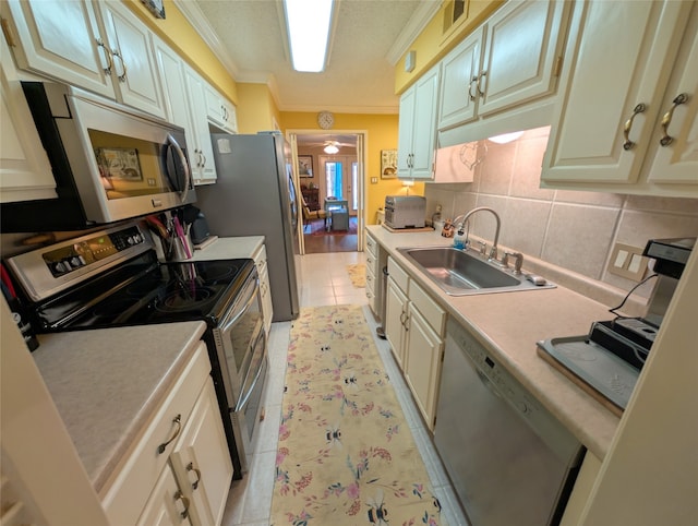 14453 Misty Meadow Ln, Houston, TX 77079 - kitchen with stainless steel appliances, crown molding, light countertops, decorative backsplash, and light tile patterned flooring