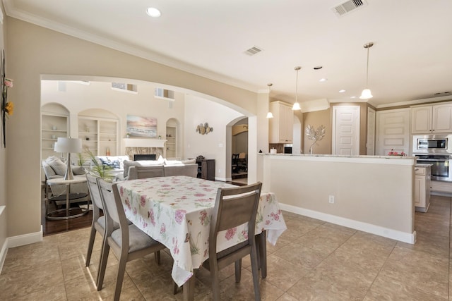 25611 Kearsley Dr, Katy, TX 77494 - dining room featuring arched walkways, crown molding, a fireplace, recessed lighting, and light tile patterned floors