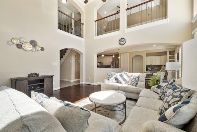 25611 Kearsley Dr, Katy, TX 77494 - living room with arched walkways, wood finished floors, a high ceiling, and a ceiling fan