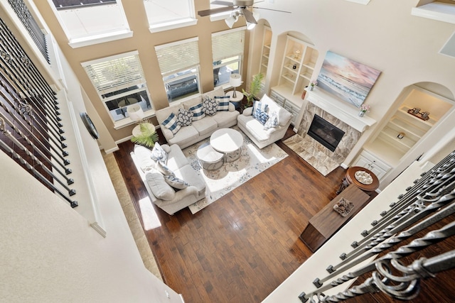 25611 Kearsley Dr, Katy, TX 77494 - living room with plenty of natural light, wood-type flooring, a glass covered fireplace, a ceiling fan, and a high ceiling