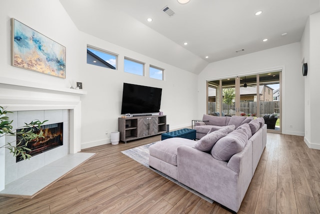 3019 Bluestem Rd, Katy, TX 77493 - living room with light wood finished floors, recessed lighting, lofted ceiling, and a tiled fireplace