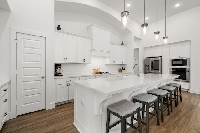 3019 Bluestem Rd, Katy, TX 77493 - kitchen featuring appliances with stainless steel finishes, white cabinets, dark wood-type flooring, a towering ceiling, and recessed lighting