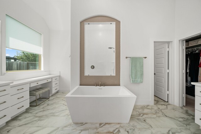 3019 Bluestem Rd, Katy, TX 77493 - bathroom featuring a freestanding tub, marble look tiles, vanity, a spacious closet, and tiled shower