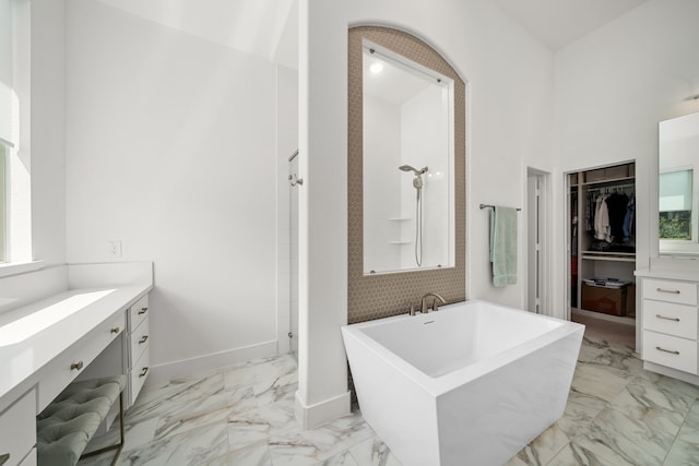 3019 Bluestem Rd, Katy, TX 77493 - bathroom with vanity, marble look tile flooring, a spacious closet, a soaking tub, and a high ceiling