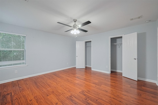 2123 Gable Hollow Ln, Katy, TX 77450 - unfurnished bedroom featuring two closets, wood finished floors, and a ceiling fan