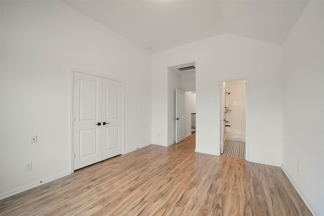 29602 Beech Tree Bnd, Fulshear, TX 77494 - unfurnished bedroom with light wood-style flooring, lofted ceiling, a closet, and ensuite bath