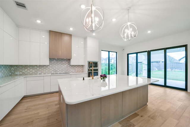 29602 Beech Tree Bnd, Fulshear, TX 77494 - kitchen featuring a chandelier, modern cabinets, light wood-type flooring, white cabinetry, and recessed lighting