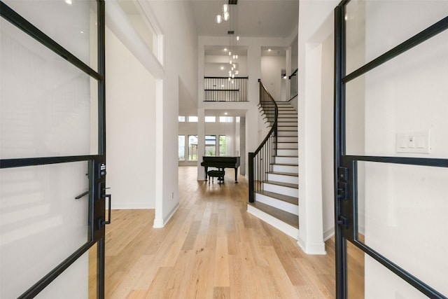 29602 Beech Tree Bnd, Fulshear, TX 77494 - entryway with light wood-style flooring, stairs, a chandelier, and a high ceiling