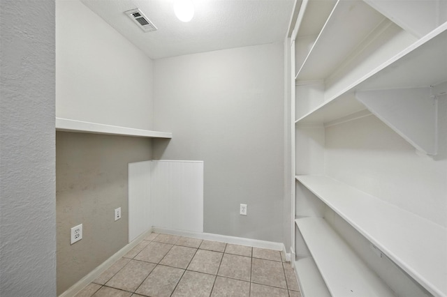 7575 Kirby Dr Unit 2204, Houston, TX 77030 - laundry room with tile patterned flooring and baseboards