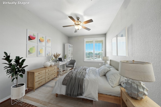 7575 Kirby Dr Unit 2204, Houston, TX 77030 - bedroom featuring a desk, wood finished floors, a textured wall, and a ceiling fan
