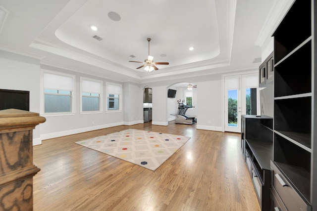 1302 Westview Garden Ct, Houston, TX 77055 - living area with a tray ceiling, ceiling fan, arched walkways, light wood finished floors, and ornamental molding