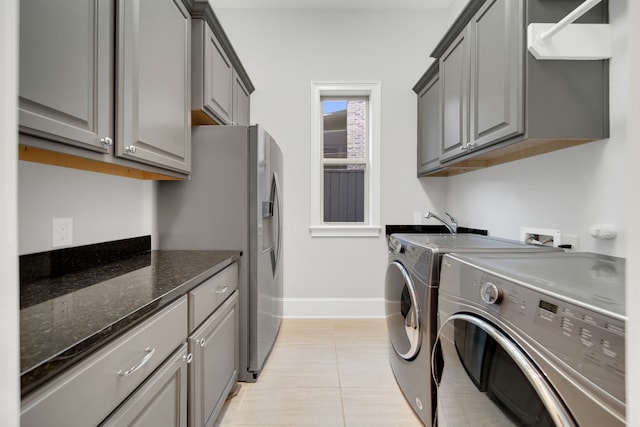 1302 Westview Garden Ct, Houston, TX 77055 - laundry room featuring washing machine and clothes dryer, cabinet space, and light tile patterned floors