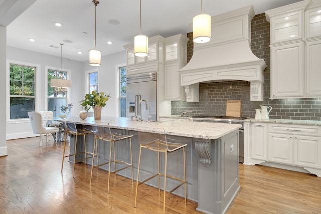 1302 Westview Garden Ct, Houston, TX 77055 - kitchen with stainless steel appliances, light wood-type flooring, decorative backsplash, light stone counters, and recessed lighting