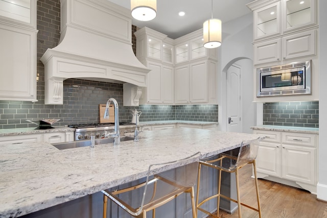 1302 Westview Garden Ct, Houston, TX 77055 - kitchen featuring stainless steel microwave, tasteful backsplash, white cabinets, and recessed lighting