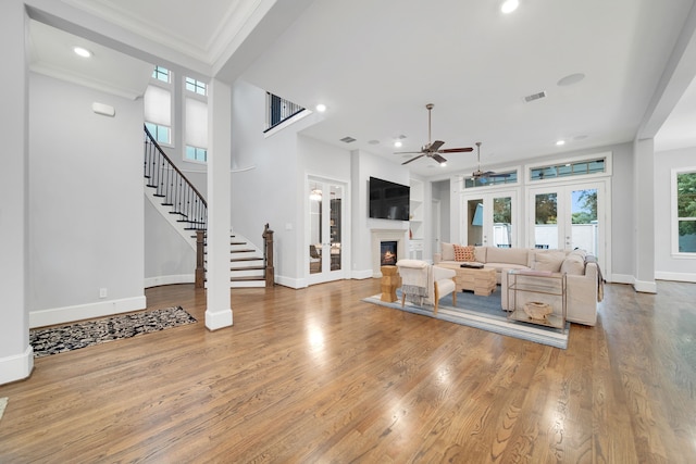 1302 Westview Garden Ct, Houston, TX 77055 - living room with a ceiling fan, a lit fireplace, stairs, wood finished floors, and crown molding
