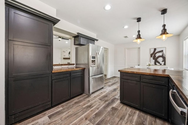 5515 Dumfries Dr, Houston, TX 77096 - kitchen with stainless steel refrigerator with ice dispenser, butcher block countertops, light wood finished floors, recessed lighting, and pendant lighting
