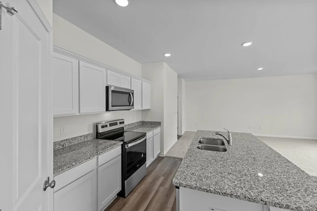 452 Harlow Dr, Montgomery, TX 77316 - kitchen with stainless steel appliances, white cabinets, light stone counters, recessed lighting, and a kitchen island with sink