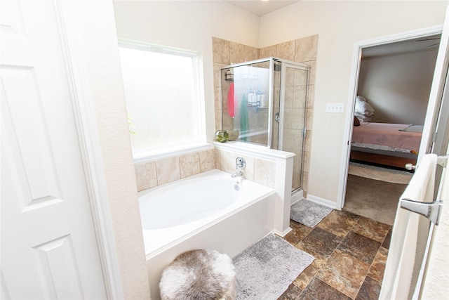 8222 Pastel Dawn Trce, Houston, TX 77049 - ensuite bathroom featuring a stall shower, a bath, and stone finish flooring