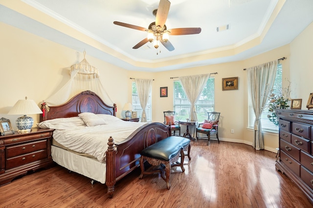 16018 Lower Lake Dr, Cypress, TX 77433 - bedroom featuring a raised ceiling, wood finished floors, crown molding, and a ceiling fan