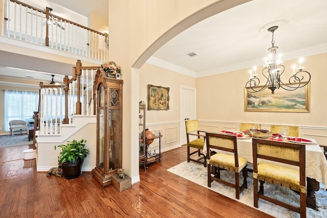 16018 Lower Lake Dr, Cypress, TX 77433 - dining area featuring arched walkways, crown molding, a chandelier, wood finished floors, and wainscoting